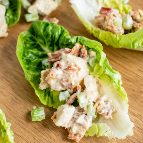 A bacon and chicken ranch salad with mayo stuffed into a gem lettuce leaf on a wooden background