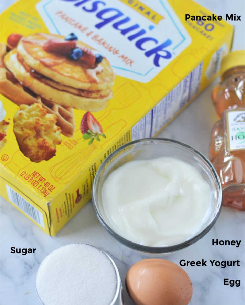 Overhead shot of ingredients required for pancake muffins: pancake mix, yogurt, sugar, honey and egg