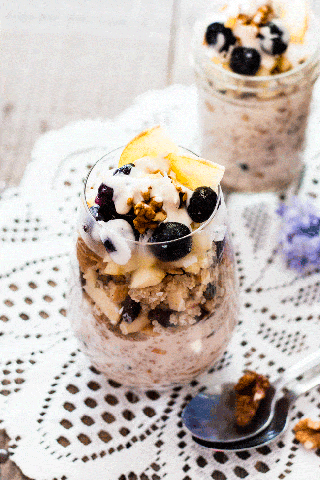 quinoa overnight oats served in a glass and topped with fresh apple and blueberries