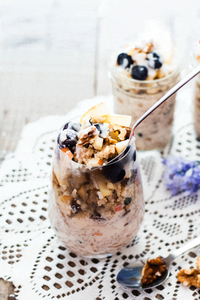 Breakfast parfaits served in glasses and mason jars and topped with apple and blueberries