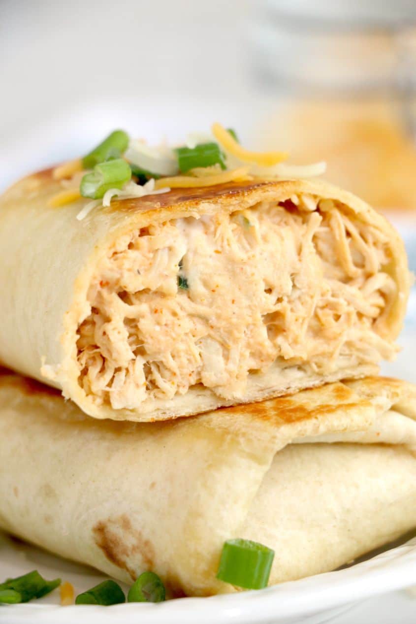 Spicy buffalo chicken wraps stacked one on top of the other with a sprinkle of fresh chopped cilantro on top