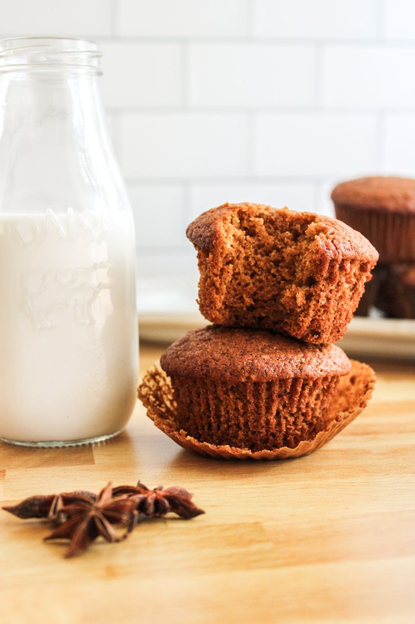 A stack of two pumpkin pie spice muffins on top of each other with a bottle of fresh milk in the background