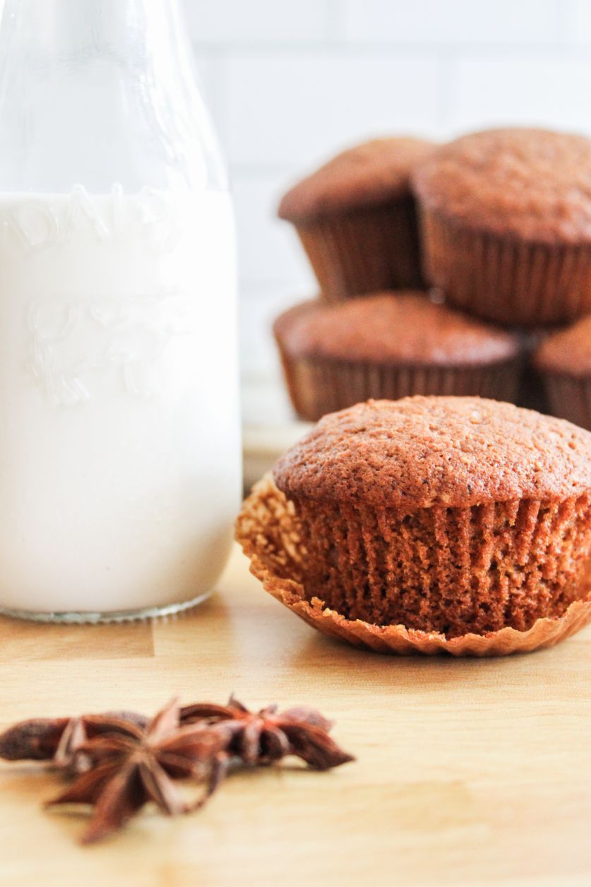 A stack of muffins with a jug of fresh milk in the background and some star anise in the front