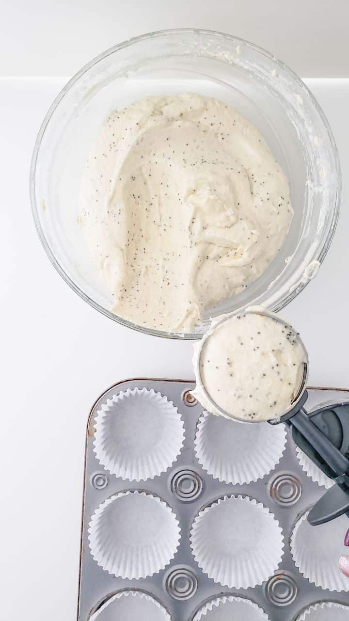 A large spoon scooping muffin batter into prepared muffin tins