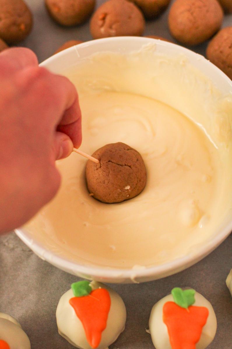 Use a toothpick to roll cake balls in melted white chocolate