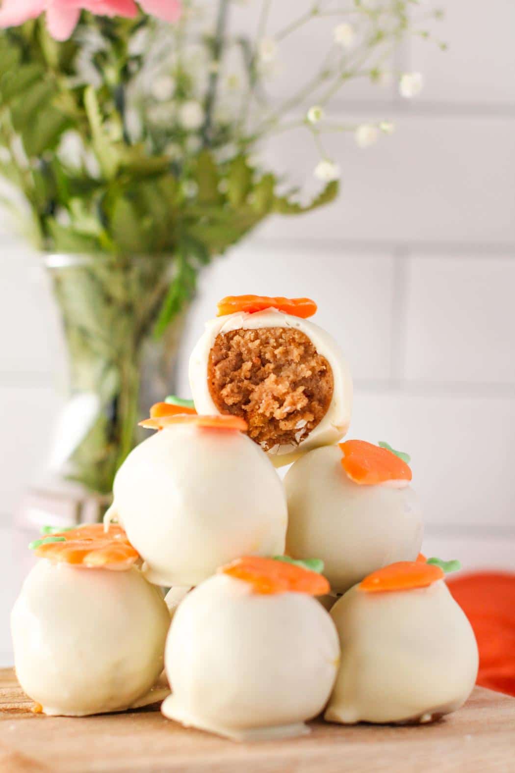 6 carrot cake balls stacked on a wooden board