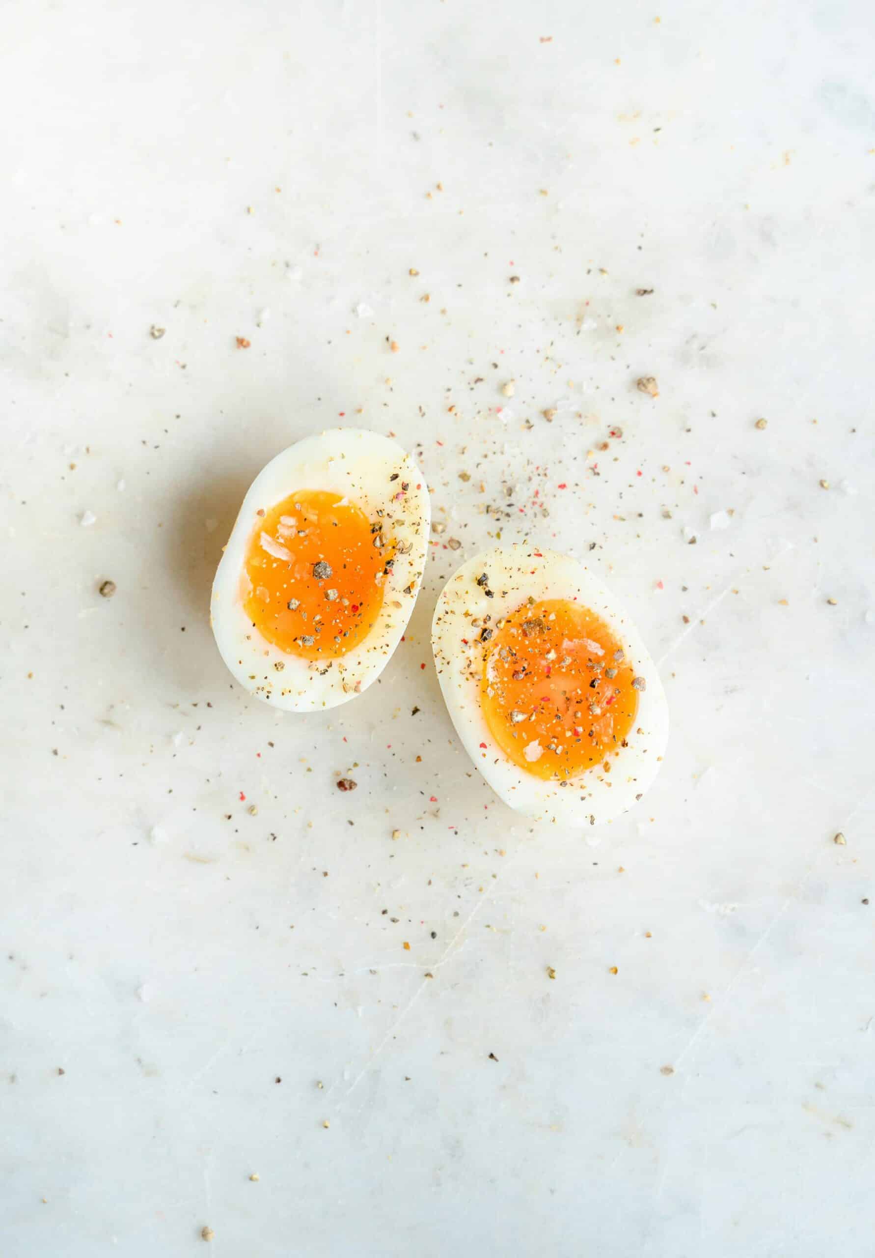 Overhead shot of some hard boiled eggs topped with salt and pepper