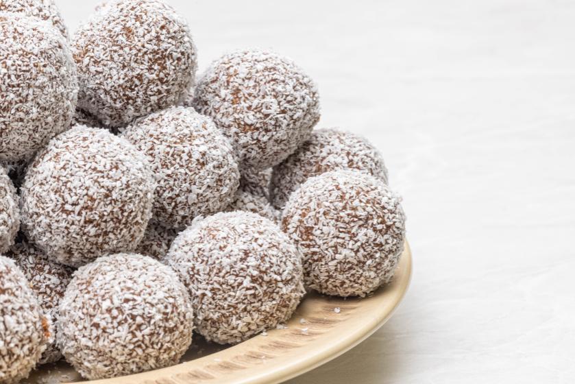 A stack of coconut and milo balls on a beige plate